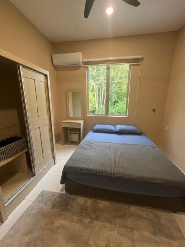 a bedroom with a bed and a window at Exclusive Changlun Room in Bukit Kayu Hitam