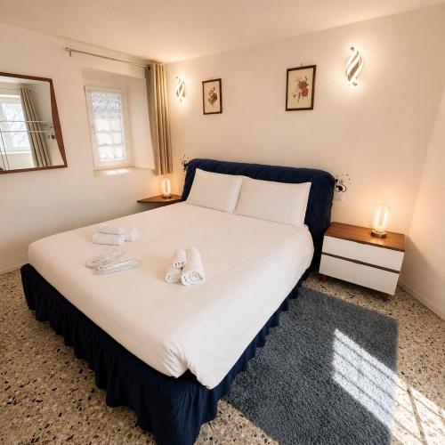 a bedroom with a large bed with towels on it at Tra i laghi lago maggiore e lago d'orta in Invorio Inferiore