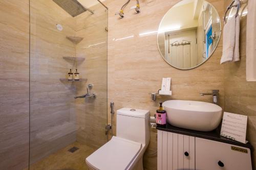 a bathroom with a toilet and a sink and a mirror at The Walnut Stays in Solan