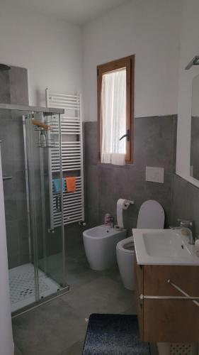 a bathroom with a shower and a toilet and a sink at L'Officina in Leverano