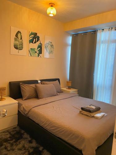 a bedroom with a large bed and a window at 45ft Floor with Fast Wi-Fi Pool & Gym Access in Manila