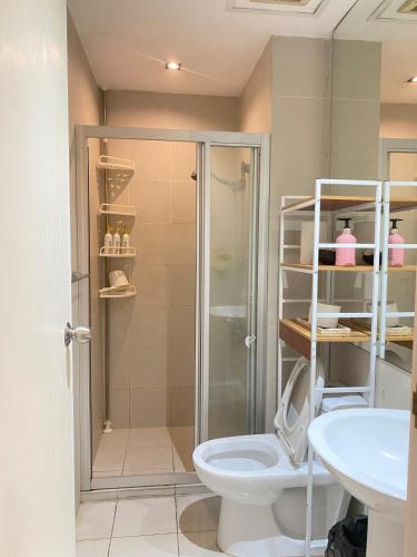 a bathroom with a shower and a toilet and a sink at 45ft Floor with Fast Wi-Fi Pool & Gym Access in Manila