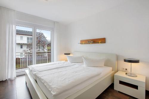 a white bed in a room with a large window at Weinregion direkt vor der Tür erleben - Ferienwohnung Weinberg in Bad Bellingen