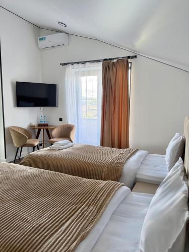 a hotel room with two beds and a television at Davos Hotel in Pʼarakʼar
