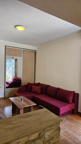 a living room with a red couch and a table at Aura Bay Cozy Studio in Kotor