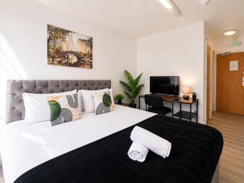 a bedroom with a large white bed and a television at Sangha House - Ensuite Rooms with Shared Kitchen Facilities in Leicester