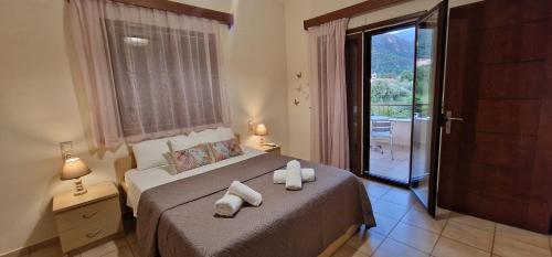 a bedroom with a bed with two towels on it at Karras Apartments in Gliki