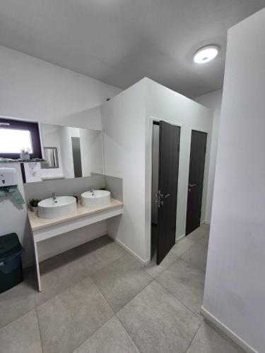 a large bathroom with two sinks and two mirrors at Aqua Sia in Sighetu Marmaţiei