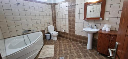 a bathroom with a tub and a toilet and a sink at Karras Apartments in Gliki