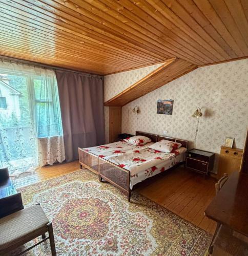 a bedroom with a bed and a wooden ceiling at Guest House Raisa in Dilijan