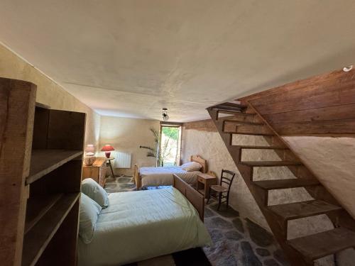 a room with two beds and a staircase in a house at La grange de Jean et Claude in Barre-des-Cévennes