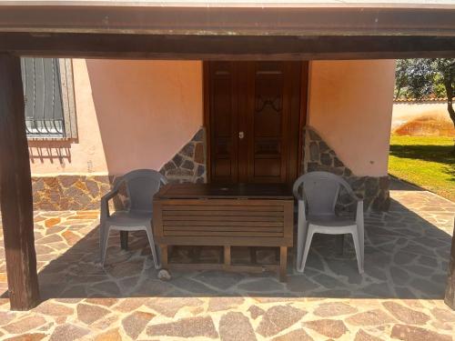 two chairs and a wooden table on a patio at Locazione Turistica Antonella in Fiumicino