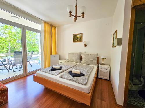 a bedroom with a large bed and a large window at Weinberger Vendégház in Zamárdi