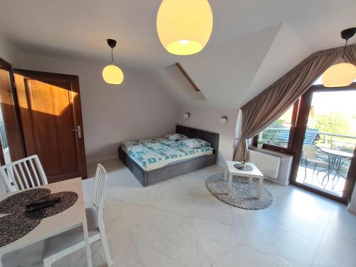 a bedroom with a bed and a table and chairs at Willa Na Zboczu in Chmielno