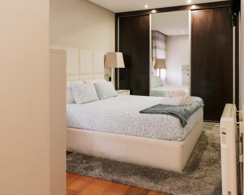 a bedroom with a bed and a mirror at Lourença Stays - Vila Beach Apartment 1 in Vila do Conde