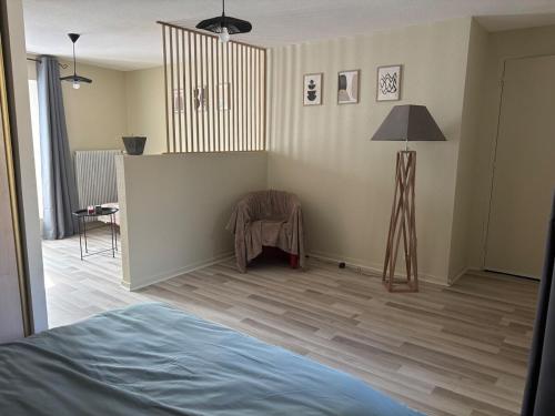 a room with a bed and a lamp in it at Appartement - Baume-les-Dames in Baume-les-Dames