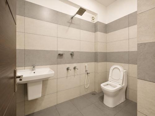 a bathroom with a toilet and a sink at Raaha Residency in Kozhikode