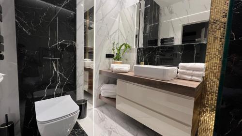 a bathroom with a white toilet and a sink at Wejdz na Housine,pl Zator in Zator