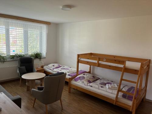 two bunk beds in a room with a table and chairs at PENZION VLASTA in Zlín