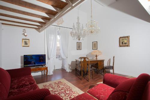 un soggiorno con un divano rosso e un tavolo di Corso Vittorio Apartment a Trapani