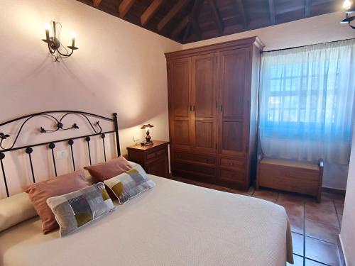 a bedroom with a bed and a dresser and a window at Panchita in Garafía