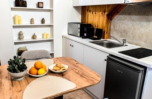 eine Küche mit einem Holztisch, auf dem Orangen liegen in der Unterkunft Araxos Loft in Áraxos