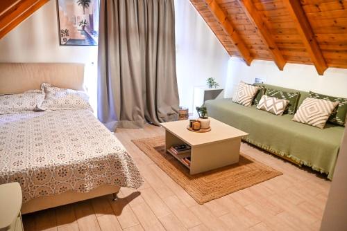 ein Schlafzimmer mit einem Bett und einem Couchtisch in der Unterkunft Araxos Loft in Áraxos