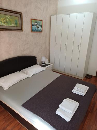 a bedroom with a large bed with towels on it at Room Rada in Ulcinj