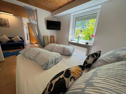 a bedroom with two twin beds and a window at Gemütliche Ferienwohnung nähe Schloss Benrath & Rhein Düsseldorf Urdenbach in Düsseldorf