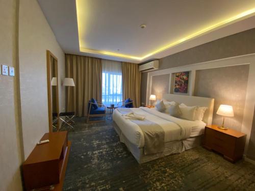 a hotel room with a large bed and a desk at Skoop Jeddah in Jeddah