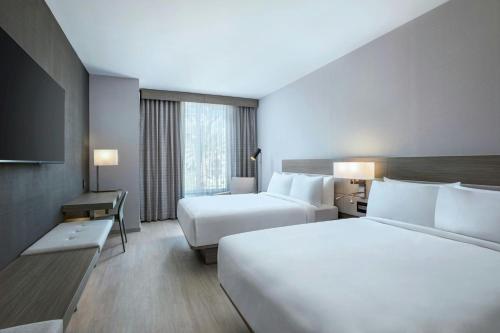 a hotel room with two beds and a television at AC Hotel by Marriott Las Vegas Symphony Park in Las Vegas