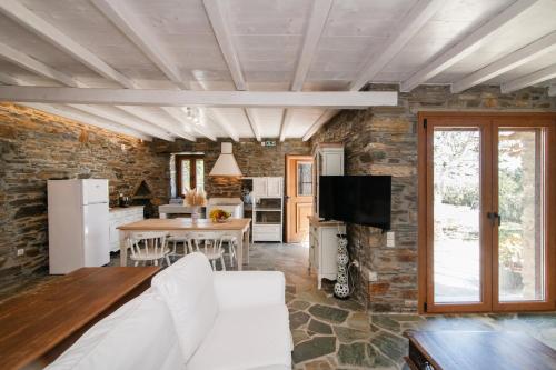a kitchen and living room with a stone wall at Liostasi Tinos in Agios Fokas
