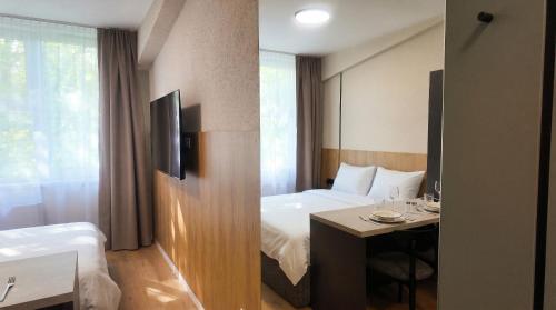 a hotel room with a bed and a desk with a table at Axiom Suites - Nova 3 in KoÅ¡ickÃ© KÃºpele