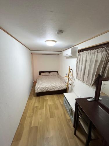 a small bedroom with a bed and a desk at Shalom House Yokosuka in Yokosuka