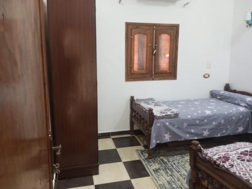a room with two beds and a door with a mirror at Winjee in Abu Simbel