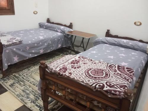 a room with two beds and a table at Winjee in Abu Simbel