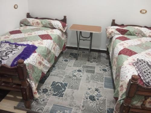 a room with two beds and a table on the floor at Winjee in Abu Simbel
