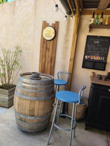 a bar with a barrel and a table and stool at Le QG chez Flo et David in Saint-Julien-Molin-Molette