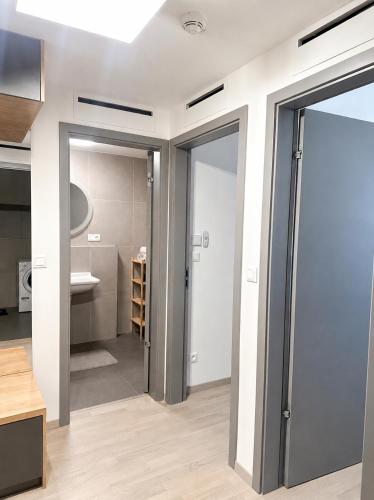 a bathroom with a door open to a bathroom with a sink at Harmony Metropolis Bratislava Free Parking in Nivy