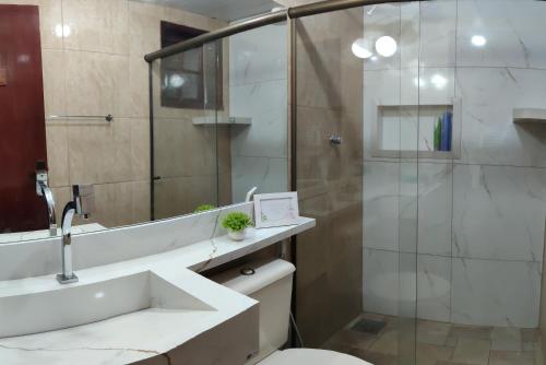 a bathroom with a shower and a toilet and a sink at Refúgio Peró - Praia, piscina e churrasqueira in Cabo Frio