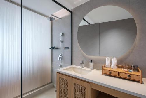 a bathroom with a sink and a mirror at Jun hade on hillside in Hangzhou
