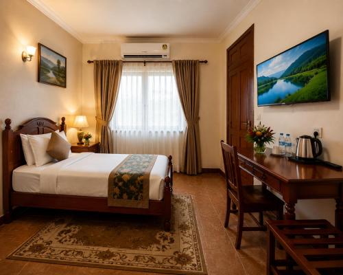 a hotel room with a bed and a desk and a computer at Kagera Breeze Resort in Mbarara