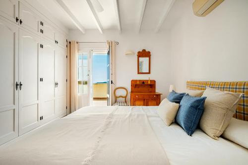 a bedroom with a large white bed with blue pillows at Villa Atréju in Cómpeta