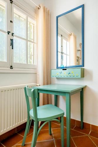 a green dressing table with a mirror and a chair at Villa Atréju in Cómpeta