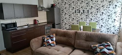 a living room with a brown couch in a kitchen at Vita apartment in Vilnius