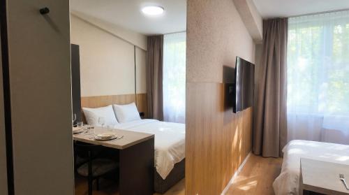 a hotel room with a bed and a desk in it at Axiom Suites - Nova 7 in KoÅ¡ickÃ© KÃºpele