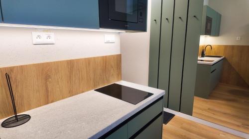 a small kitchen with a counter and a sink at Axiom Suites - Nova 7 in KoÅ¡ickÃ© KÃºpele
