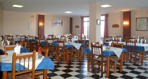 a room filled with tables and chairs with blue and white at Hostal Arias in Zafra