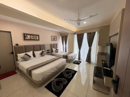 a bedroom with a bed and a flat screen tv at Hotel Prominent Town in Ahmedabad