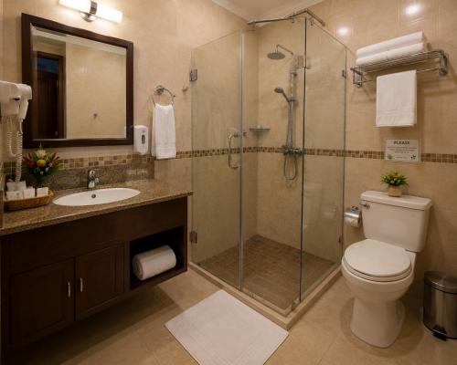 a bathroom with a shower and a toilet and a sink at Kagera Breeze Resort in Mbarara